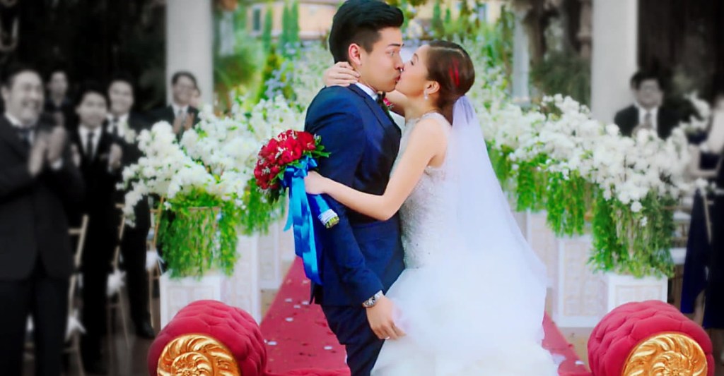 Rocky (Kim Chiu) kissing Rocco (Xian Lim) at their wedding, with Rocco looking very surprised.