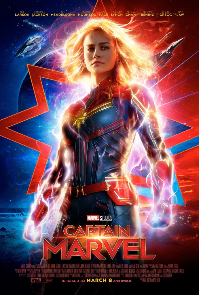 The film poster showing Vers/Carol Danvers (Brie Larson) in her Captain Marvel outfit, energy flowing through her.