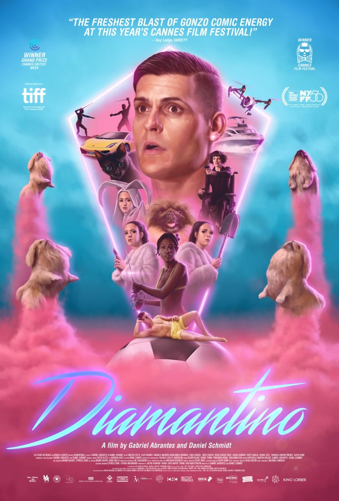 The film poster showing a pink diamond shape emerging from a soccer ball that is placed in pink mist. Four dogs are rising next to the shape on pink clouds like rockets. within the shapes are the main characters of the film, biggest Diamantino (Carloto Cotta) with a stunned facial expression.