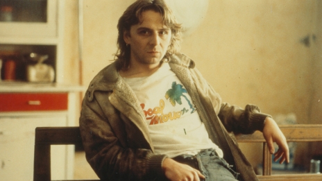 Robert (Hansi Lang) sitting with a defiant stare.