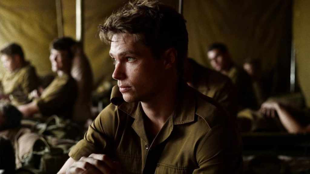 Nicholas (Kai Luke Brummer) in a tent with other soldiers.