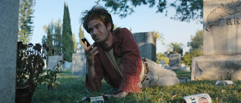 Sam (Andrew Garfield) lying in a graveyard.