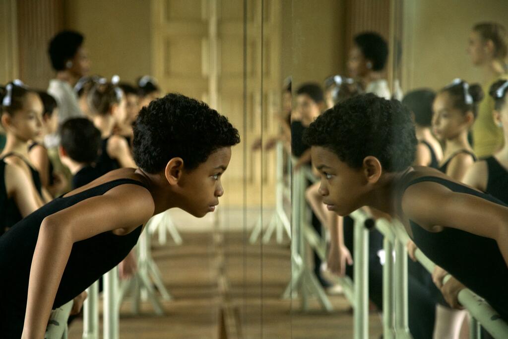 Young Carlos (Edlison Manuel Olbera Núñez) looking at himself in the mirror in the ballet studio. 
