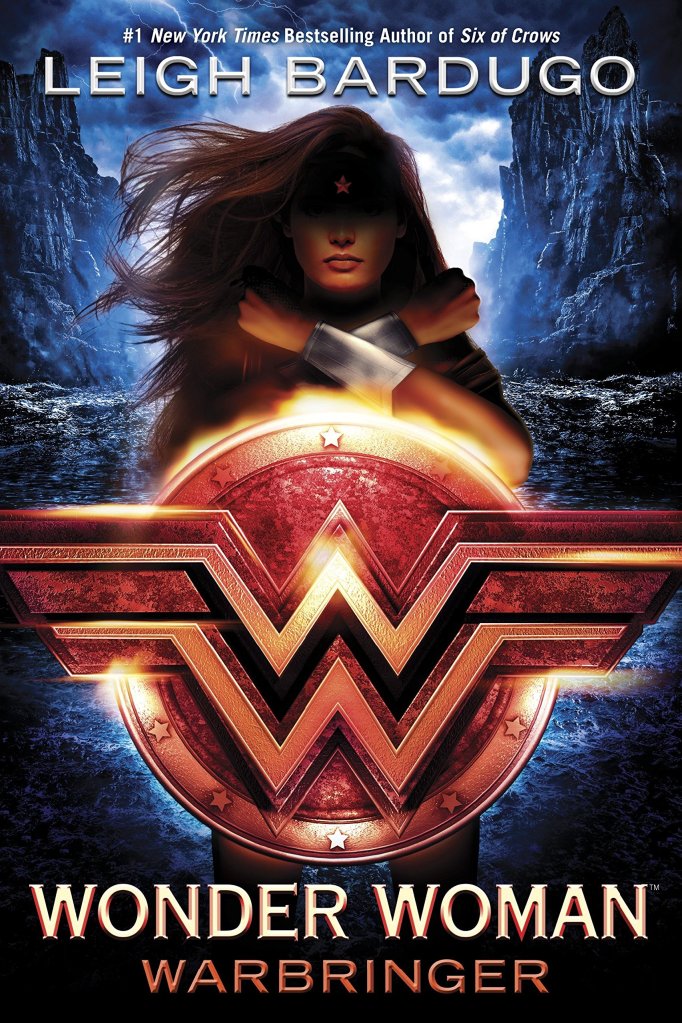 The book cover showing Wonder Woman, her hair blowing in the wind, her face shadowed, her arms crossed in front of her chest behind a shield with her emblem. 