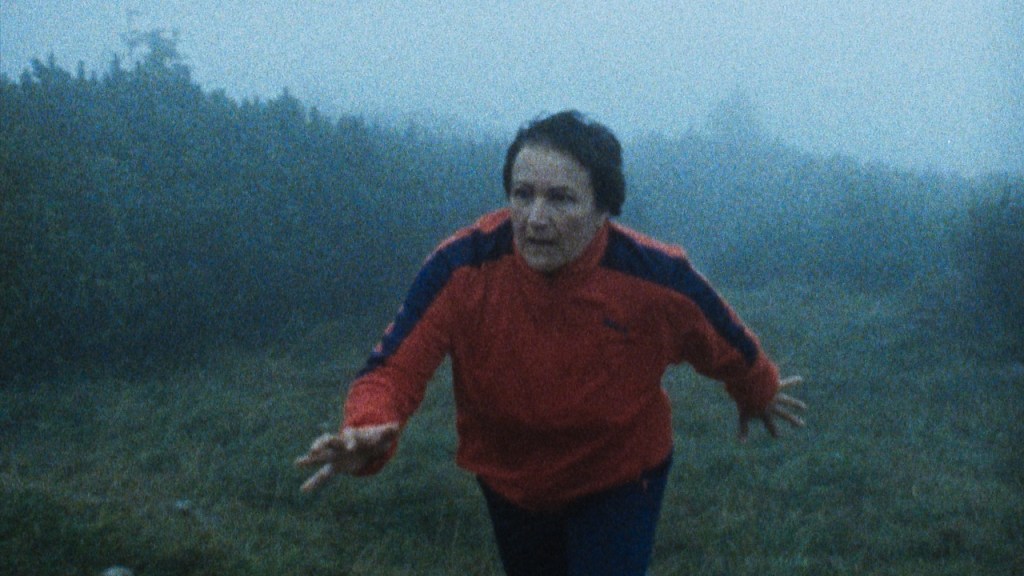 Karin (Andrea Maier) running through a foggy field. 