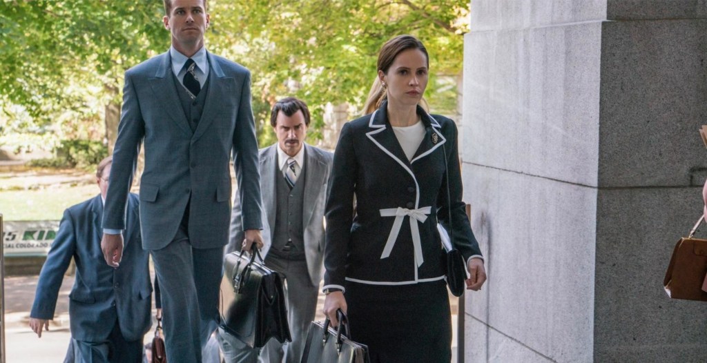 Ruth Bader Ginsburg (Felictiy Jones) walking into a courthouse, followed by her husband Martin Ginsburg (Armie Hammer).
