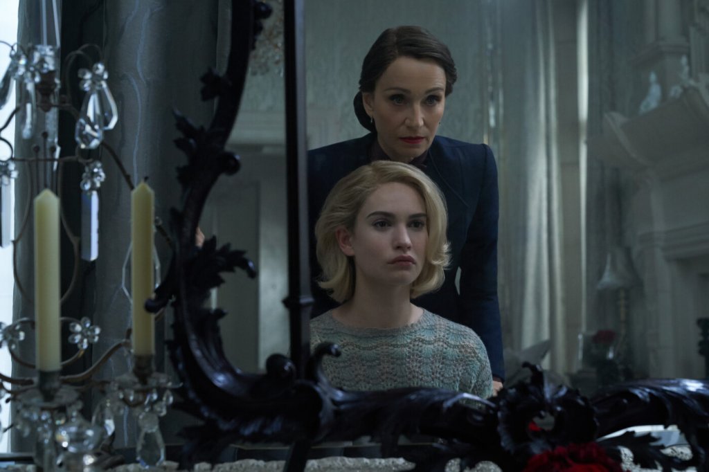 The protagonist (Lily James) looking in a mirror with Mrs Danvers (Kristin Scott Thomas) standing behind her.