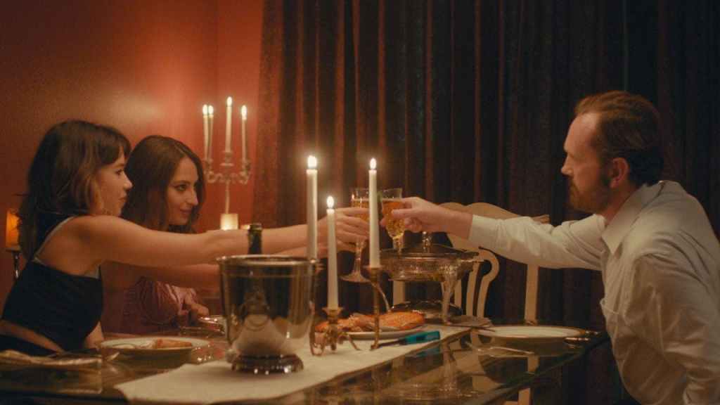 Annie (Nichole Sakura) and Jules (Fabianne Therese) having dinner with Frank (Pat Healy). 