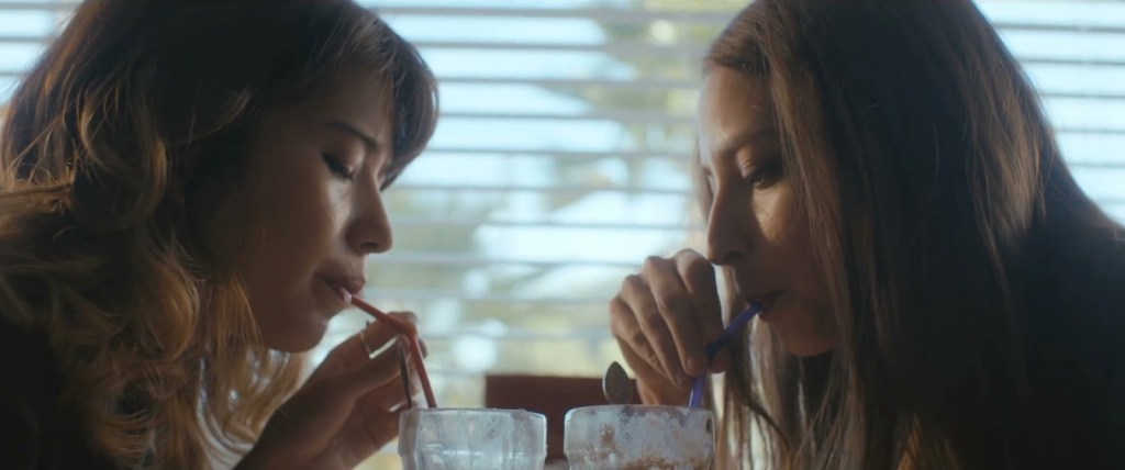 Annie (Nichole Sakura) and Jules (Fabianne Therese) drinking milkshakes together.