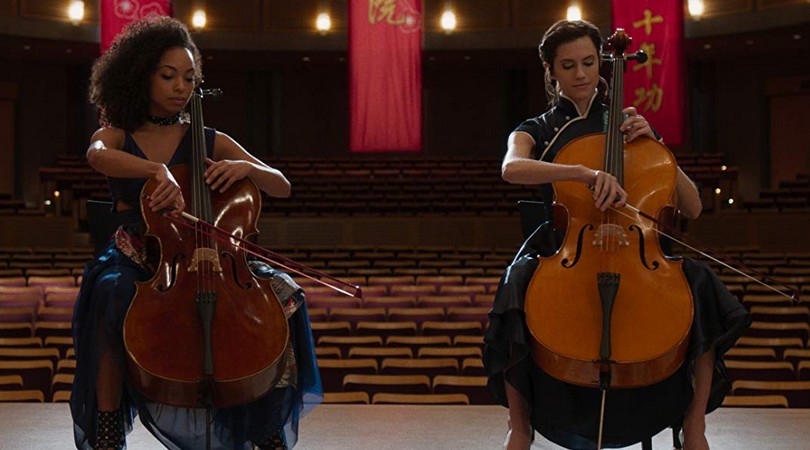 Lizzie (Logan Browning) and Charlotte (Allison Williams) playing a duet on their cellos.