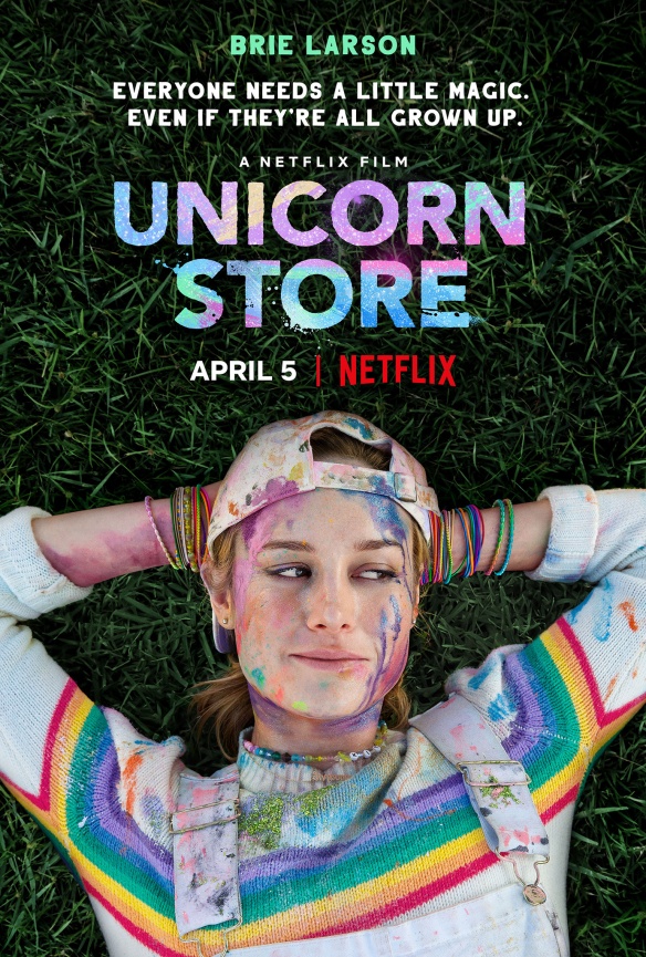 The film poster showing Kit (Brie Larson) lying on grass in a rainbow sweater covered in colorful paint.