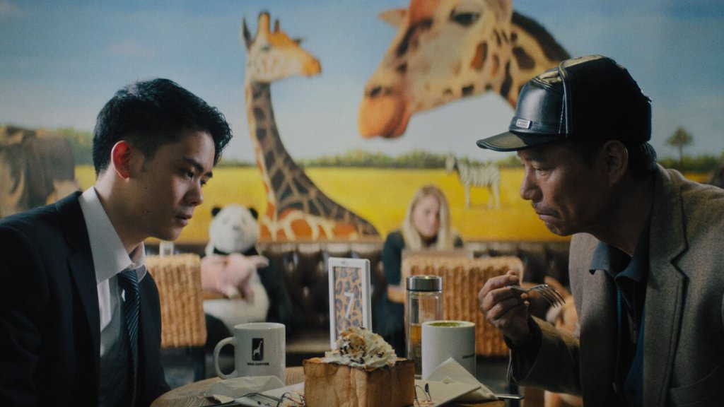 Wang Zhen (Mason Lee) at a café with his father Old Wang (Haoyu Yang).