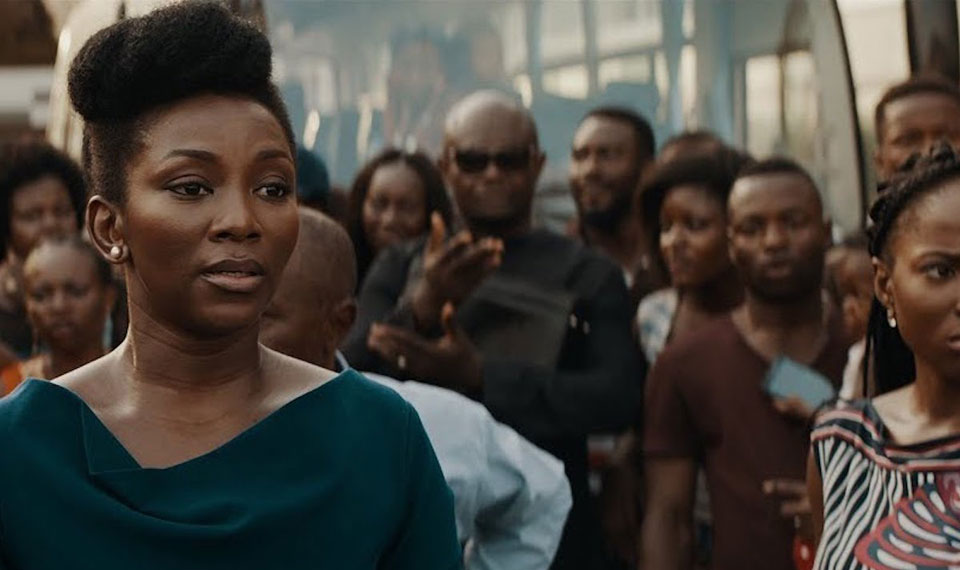 Adaeze (Genevieve Nnaji) in a crowd of people. 