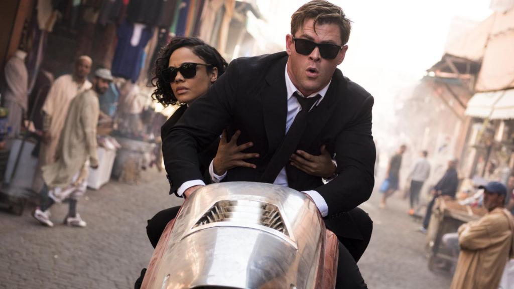 Agent M (Tessa Thompson) and Agent H (Chris Hemsworth) on a futuristic motorcycle.