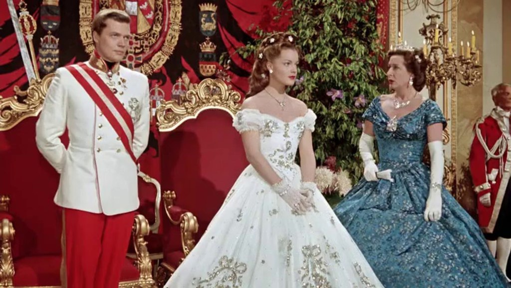 Franz Josef (Karlheinz Böhm) and Sissi (Romy Schneider) in front of their thrones with Archduchess Sophie (Vilma Degischer).