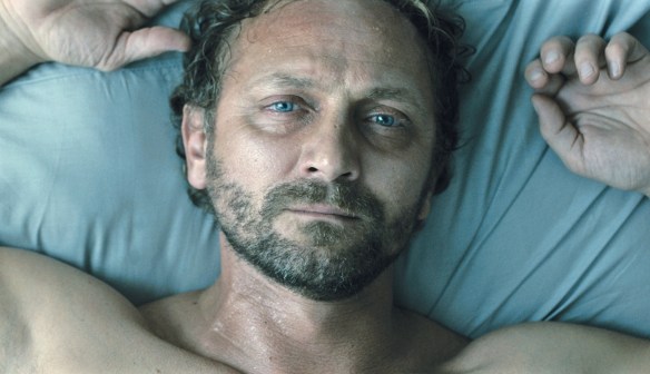 Adam (Andrzej Chyra) lying sweat-soaked in bed.