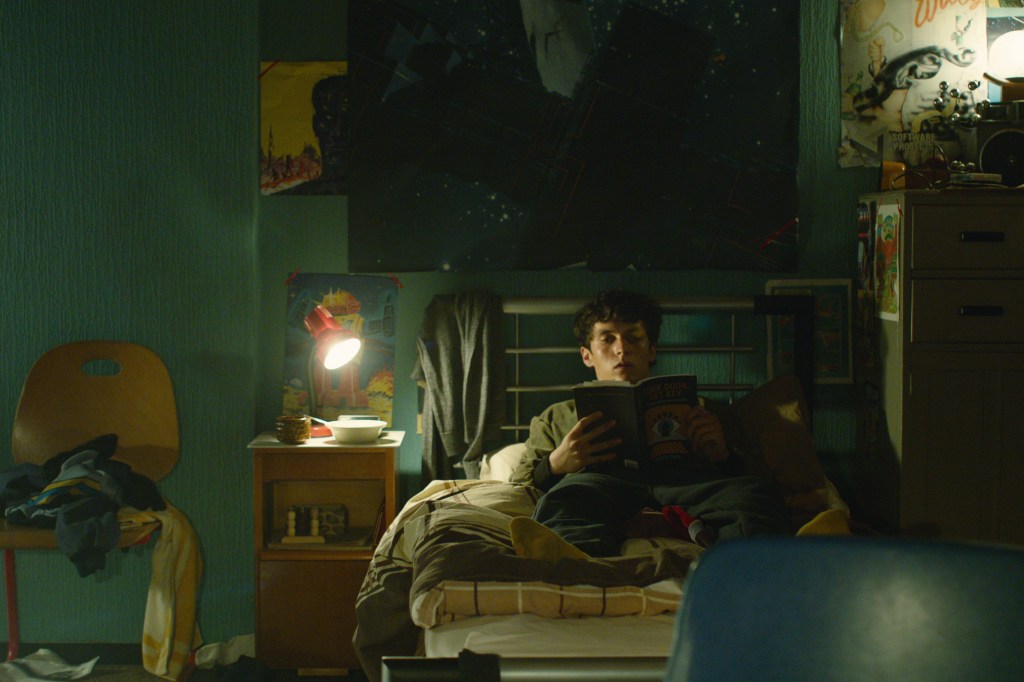 Stefan (Fionn Whitehead) reading the novel Bandersnatch in his room.