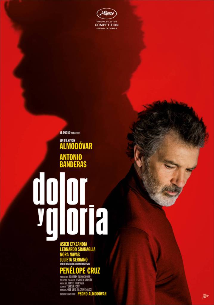 The film poster showing Salvador (Antonio Banderas) in profile, looking down and right. Behind him on the red background is a shadow that is similar to him but is looking straight ahead to the left.