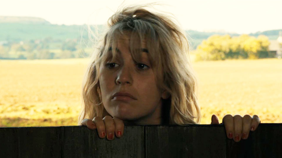 Gaby (Lolita Chammah) looking over a chin-high door.