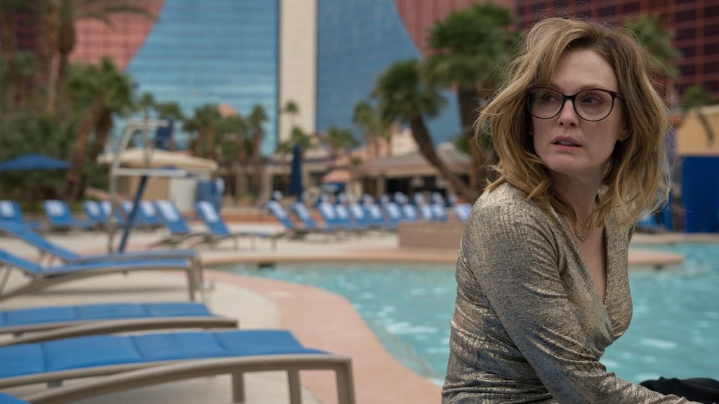 Gloria (Julianne Moore) next to a hotel pool. looking like she spent the night partying.
