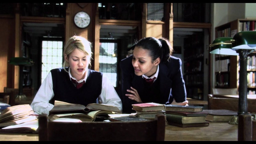 Sarah (Laura Ramsey) telling Kate (Jessica Lucas) about her research on the Sons of Ipswich.