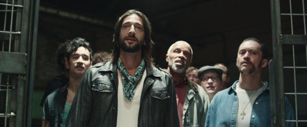 Travis (Adrien Brody) leading the other "prisoners" into the prison.