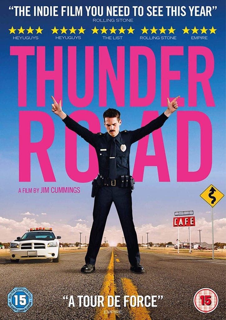 The film poster showing Jim Arnaud (Jim Cummings) in his police uniform stnading in the middle of a street, fingergunning up to the sky with both hands. 