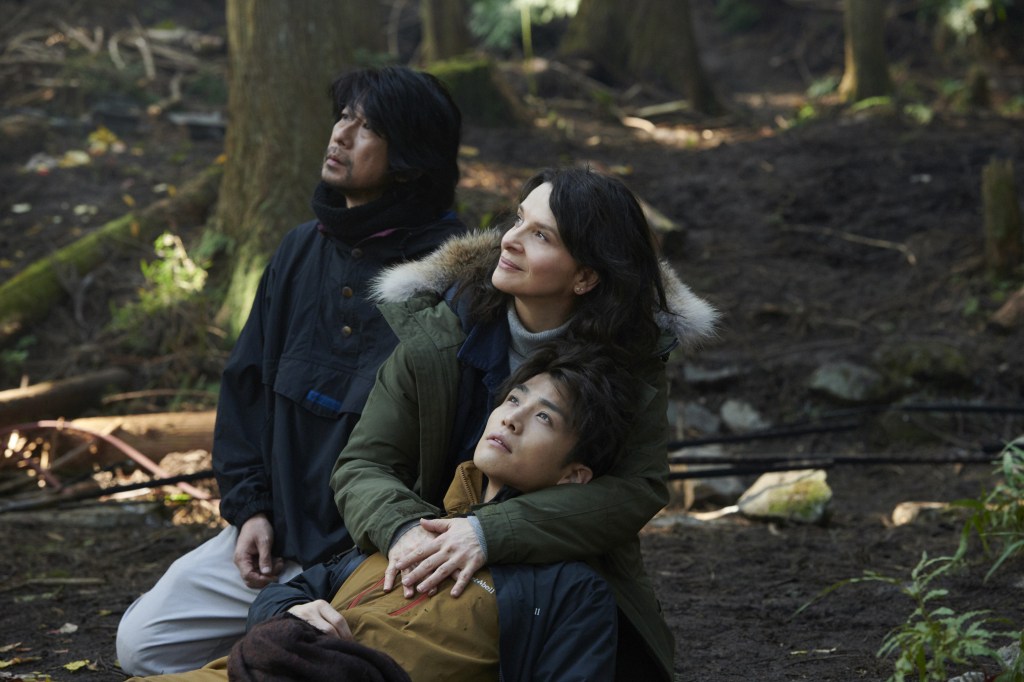 Jeanne (Juliette Binoche), Satoshi (Masatoshi Nagase) and Rin (Takanori Iwata) in the forest, with Jeanne cradling Rin in her lap.