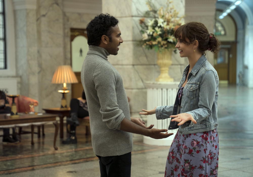Jack (Himesh Patel) and Ellie (Lily James) getting ready to hug each other as they meet in a hotel lobby.