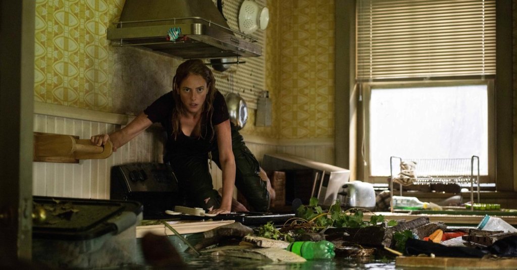 Haley (Kaya Scodelario)  crossing on the countertops through a flooded kitchen.