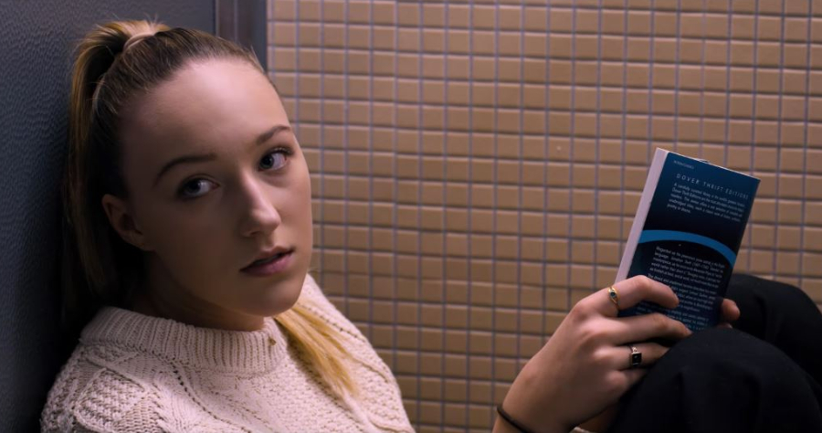 Jodi (Ava Michelle) hiding in the bathroom with a book.