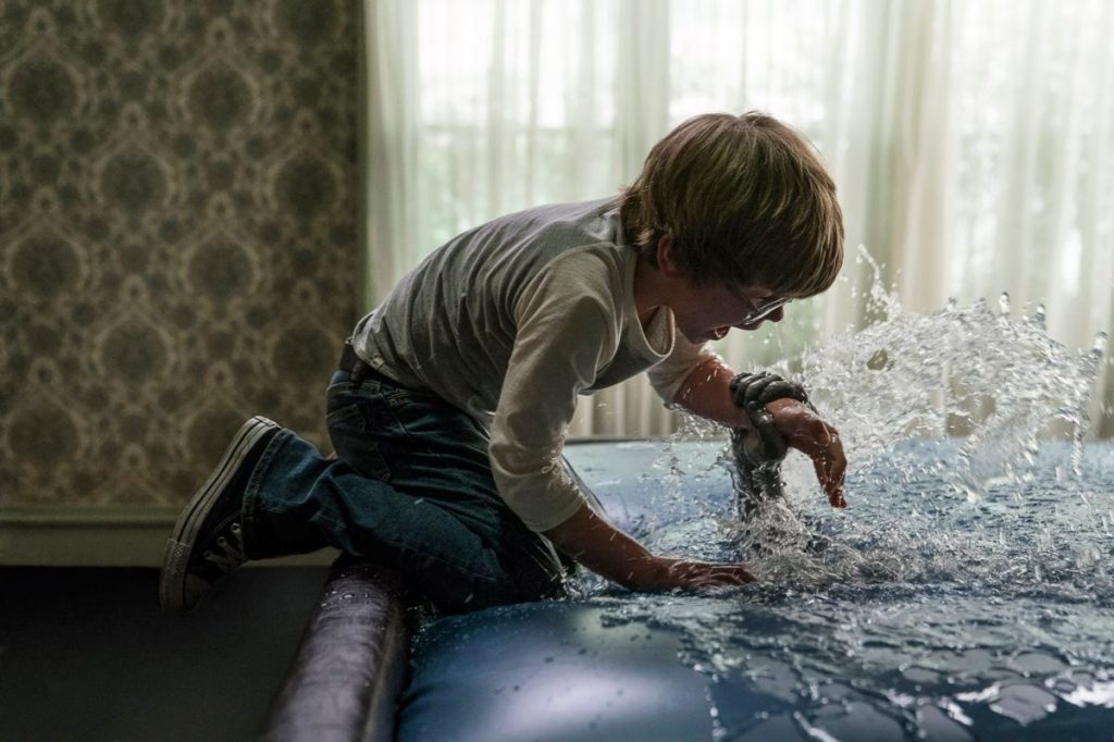 David (Julian Hilliard) being grabbed by a hand emerging from a waterbed.