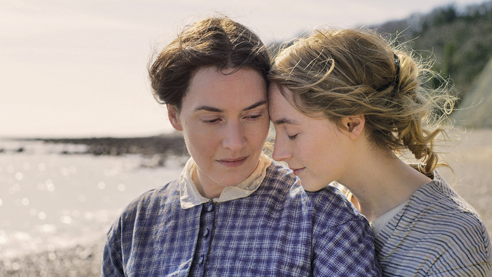 Mary (Kate Winslet) and Charlotte (Saoirse Ronan) cuddling on the beach.