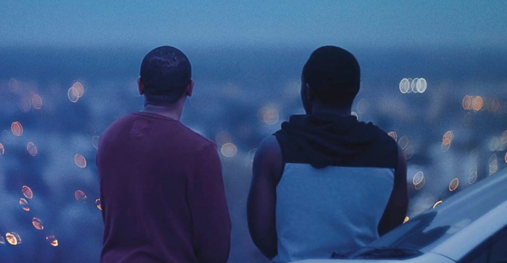 George (Adriano Visagie) and Simeon (Simon Hanga) looking over the city at night.