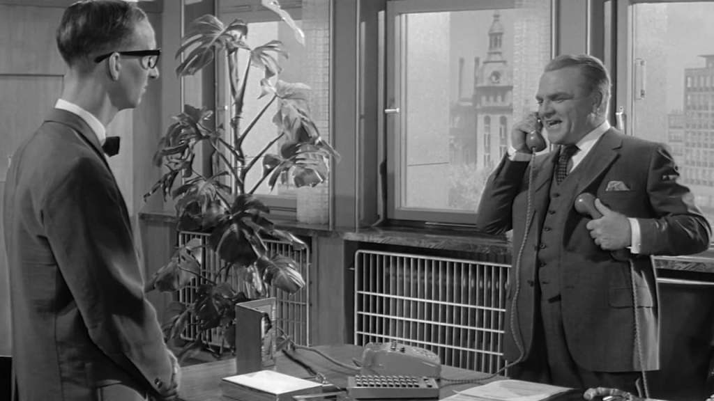 C.R. MacNamara (James Cagney) on the phone in his office.
