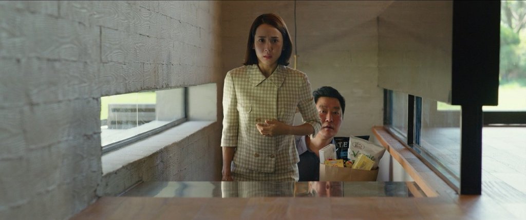 Yeon Kyo (Yeo-jeong Cho) leading Ki Taek (Kang-ho Song) into her home.
