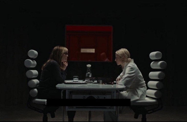 Girder (Jennifer Jason Leigh) checking in with Tasya (Andrea Riseborough) after her mission.
