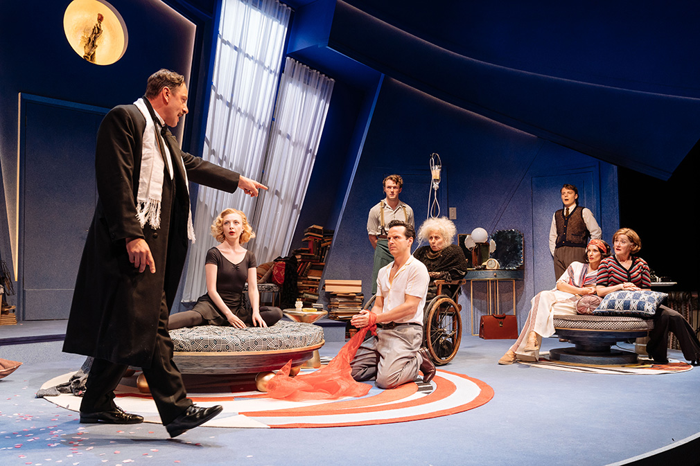 Almost the entire cast on stage in Garry's (Andrew Scott) apartment. Joe (Enzo Cilenti) is strutting angrily and points a finger at Garry.