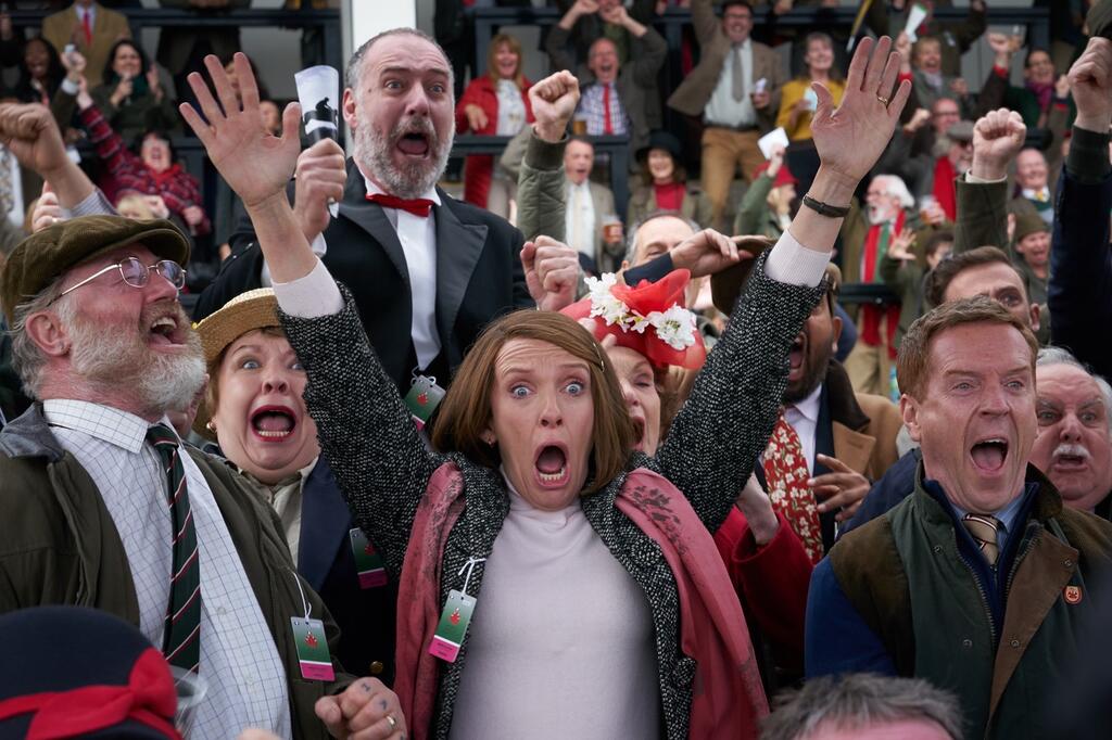 Jan (Toni Collette), Brian (Owen Teale) and Howard (Damian Lewis) and the other people in their syndicate cheering fiercely.