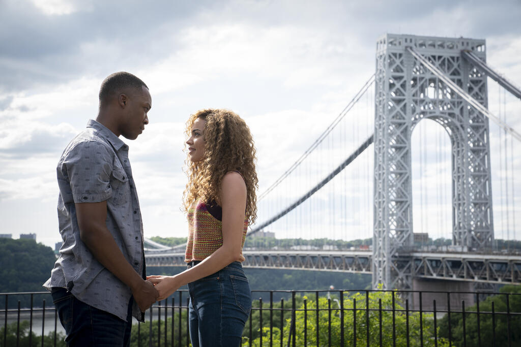 Nina (Leslie Grace) and Benny (Corey Hawkins) gazing at each other, holding hands.