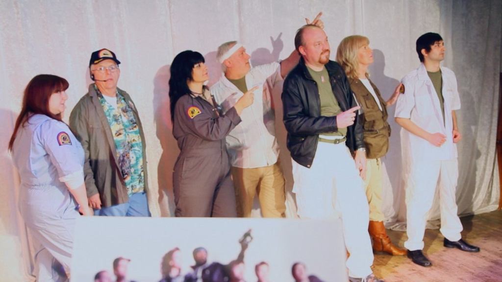 The cast of the play re-creating a famous photo of the cast of the film.