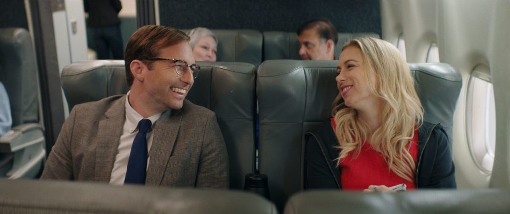 Andrea (Iliza Shlesinger) and Dennis (Ryan Hansen) talking on the plane.
