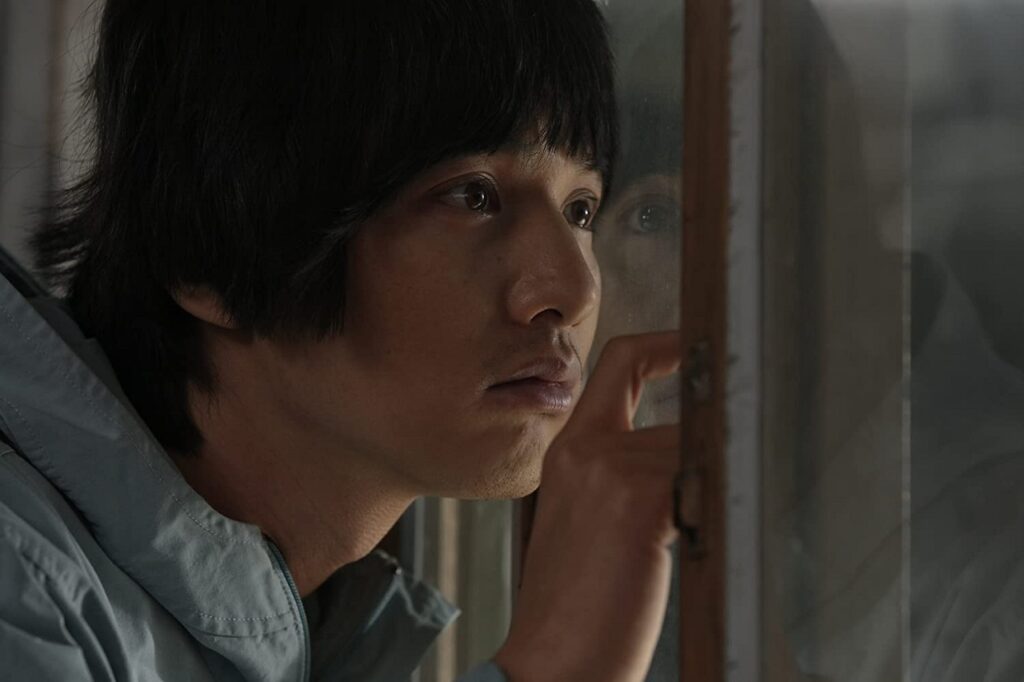 Yoon Do-joon (Won Bin) pressing his face against the partition in the prison visitor room.