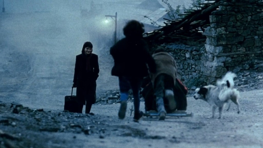 Lena (Anna Kapaleva) returning to her village, dragging a suitcase behind her.