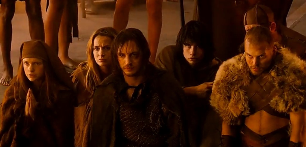 Theo (Tom Hardy) and the other abducted sacrifices kneeling.