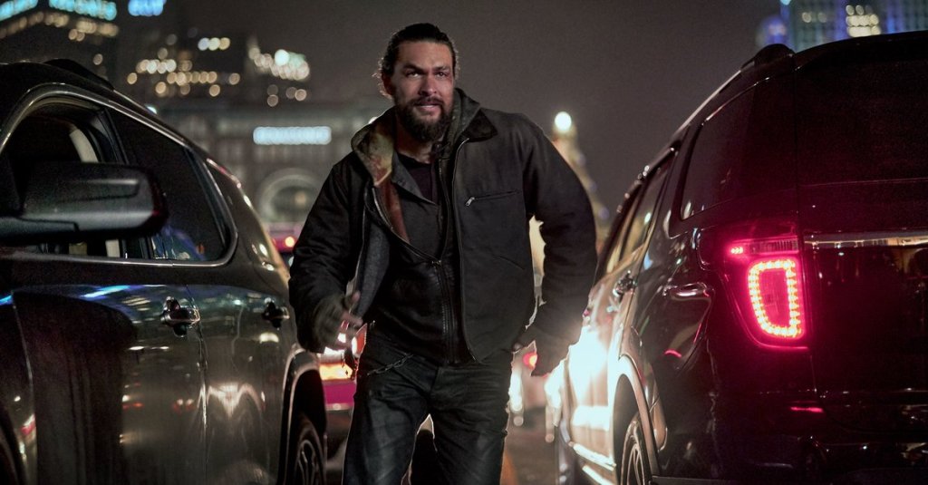 Ray (Jason Momoa) running between cars. 