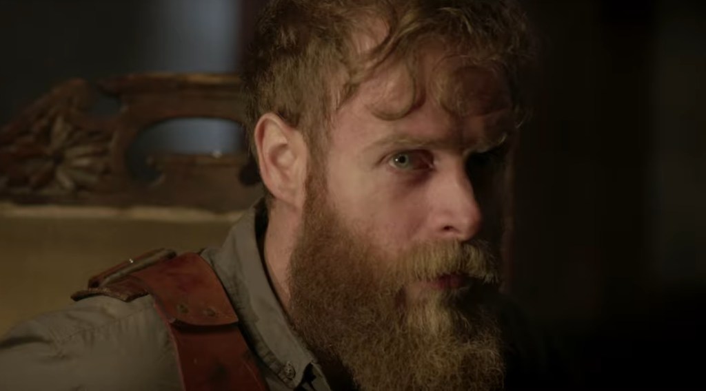 Isaac (Jonathan French) looking suspiciously at something while wearing a harness.