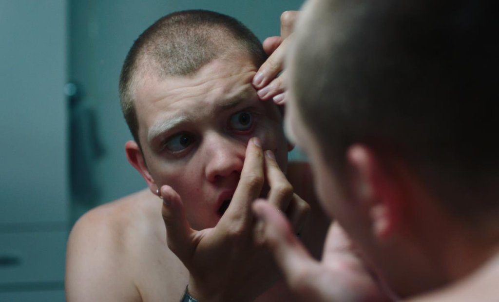Teddy (Anthony Bajon) looking at his eye in the mirror.
