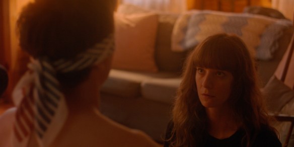 Miriam (Madeleine Sims-Fewer) kneeling in front of Dylan (Jesse LaVercombe) who is blindfolded.