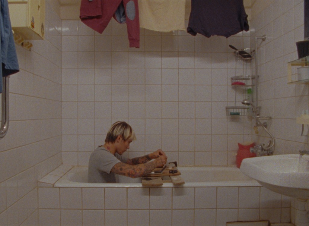 The treasureman (Denis Urvantsev) measuring drugs while sitting in a bathtub.